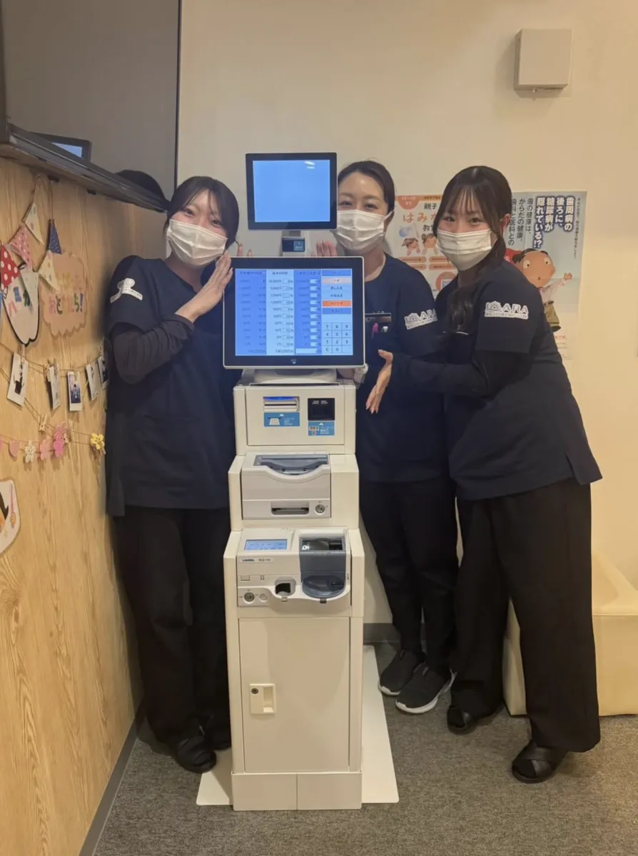 盛岡となん歯科・こども矯正歯科の受付に設置された自動精算機 PS-6 とスタッフの皆さま